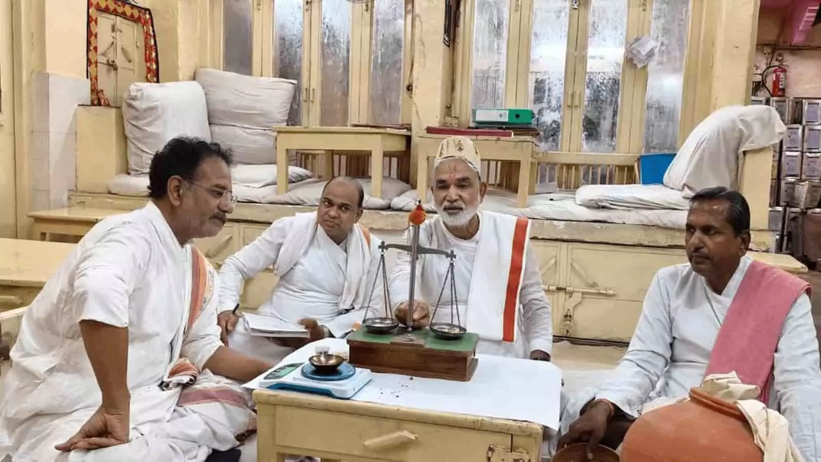 श्रीनाथजी मंदिर में आषाढ़ी तौल परंपरा के दौरान बैठे मुख्य पंड्या और कर्मचारी। श्रीनाथजी मंदिर में आषाढ़ी तौल परंपरा के दौरान बैठे मुख्य पंड्या और कर्मचारी।
