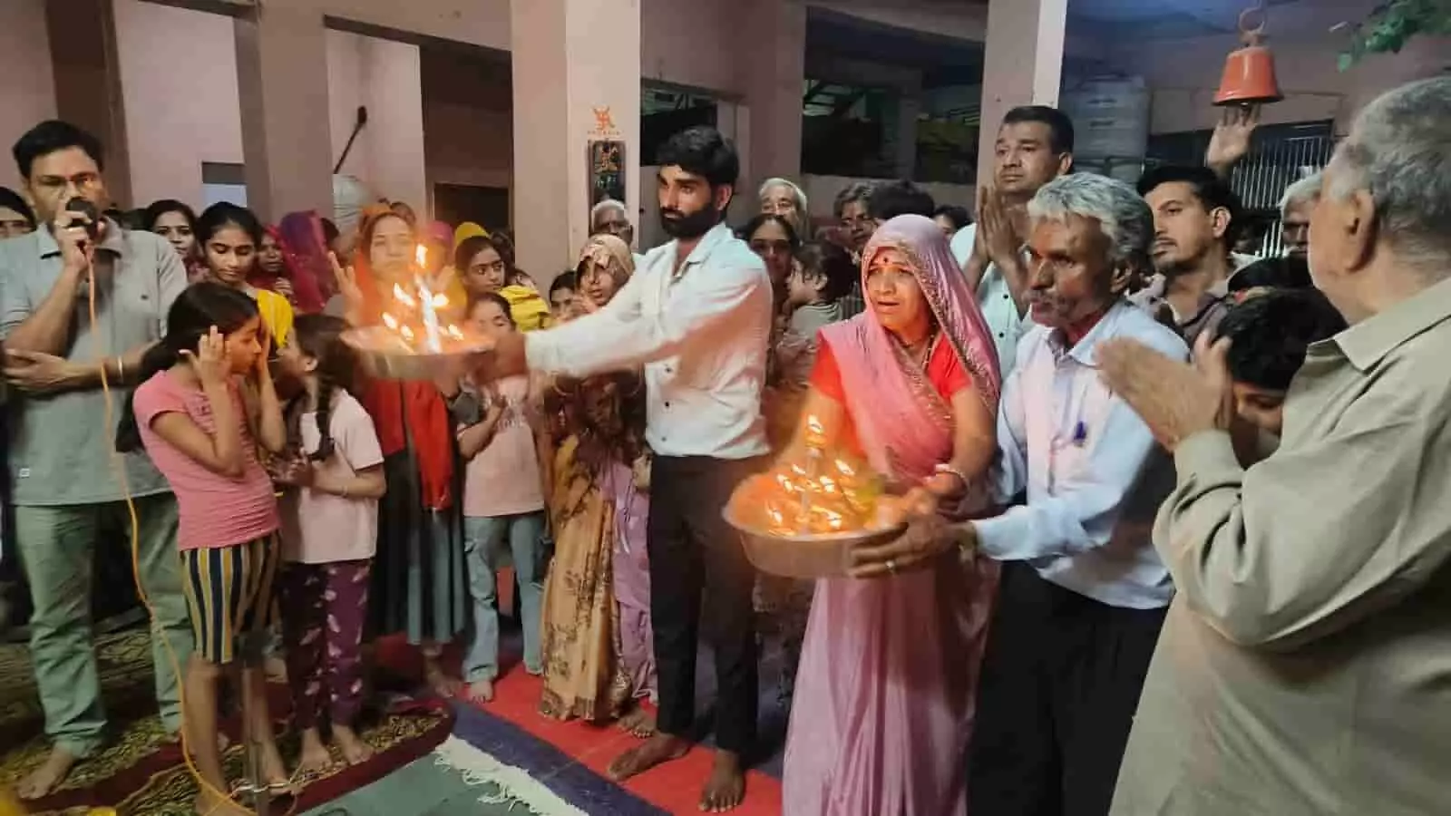 तस्वीर में मंदिर परिसर के भीतर आरती थाली थामे और ताली बजाते श्रद्धालु दिख रहे हैं। तस्वीर में मंदिर परिसर के भीतर आरती थाली थामे और ताली बजाते श्रद्धालु दिख रहे हैं।