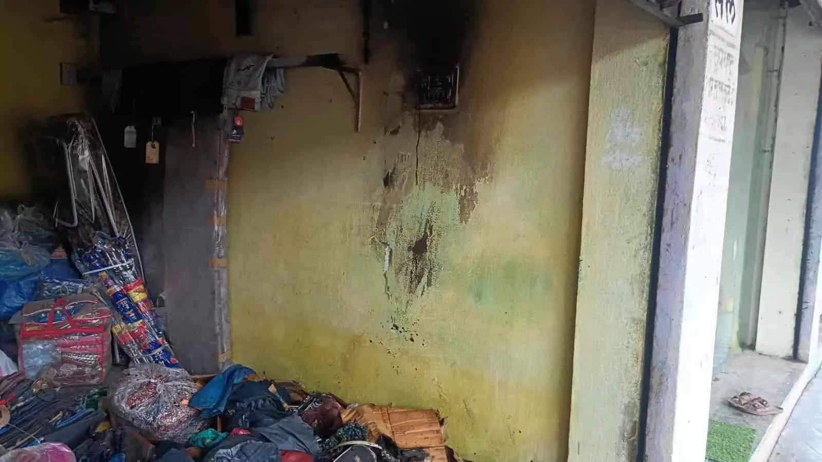 कोरपना की दुकान में आग लगने के बाद बिखरे हुए जले कपड़े और काली दीवार। कोरपना की दुकान में आग लगने के बाद बिखरे हुए जले कपड़े और काली दीवार।