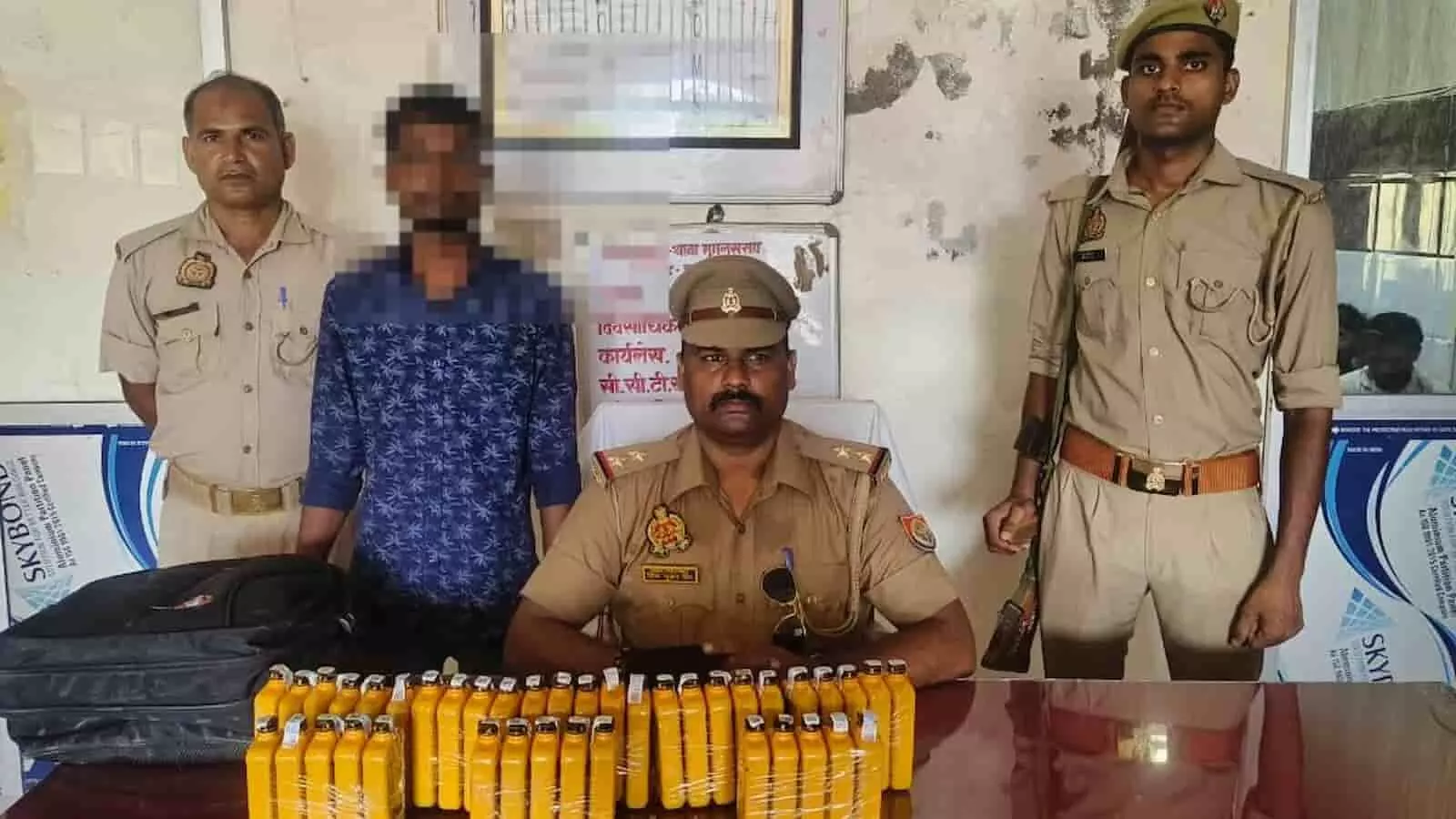 मुगलसराय थाने में जब्त शराब की बोतलों के पीछे पुलिसकर्मी और गिरफ्तार आरोपी खड़े दिख रहे हैं। मुगलसराय थाने में जब्त शराब की बोतलों के पीछे पुलिसकर्मी और गिरफ्तार आरोपी खड़े दिख रहे हैं।