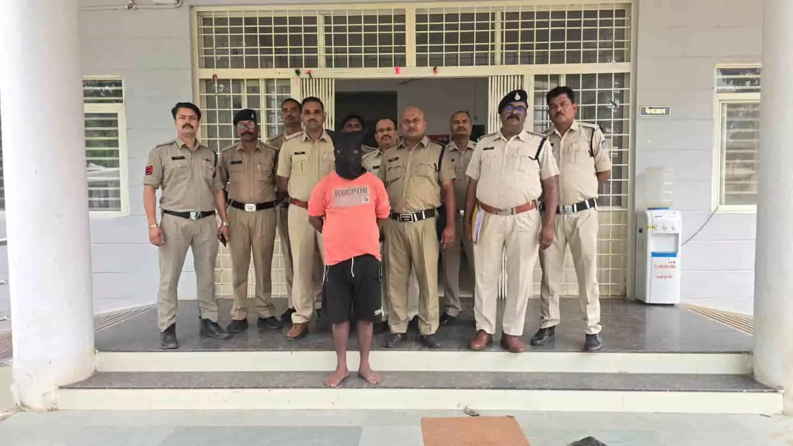 तस्वीर में पुलिसकर्मियों के साथ खड़ा ढके मुंह वाला आरोपी कटनी के रीठी पुलिस स्टेशन परिसर में दिख रहा है। तस्वीर में पुलिसकर्मियों के साथ खड़ा ढके मुंह वाला आरोपी कटनी के रीठी पुलिस स्टेशन परिसर में दिख रहा है।