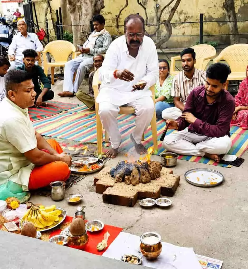 यज्ञ कुंड के पास बैठकर हवन करते हुए लोग और आचार्य ऋषभदेव में। यज्ञ कुंड के पास बैठकर हवन करते हुए लोग और आचार्य ऋषभदेव में।