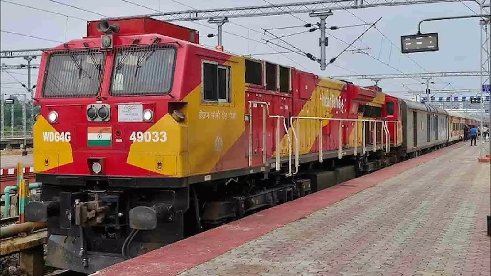 तस्वीर में रेलवे स्टेशन के प्लेटफॉर्म पर खड़ी ट्रेन और लोकोमोटिव इंजन दिख रहा है। तस्वीर में रेलवे स्टेशन के प्लेटफॉर्म पर खड़ी ट्रेन और लोकोमोटिव इंजन दिख रहा है।