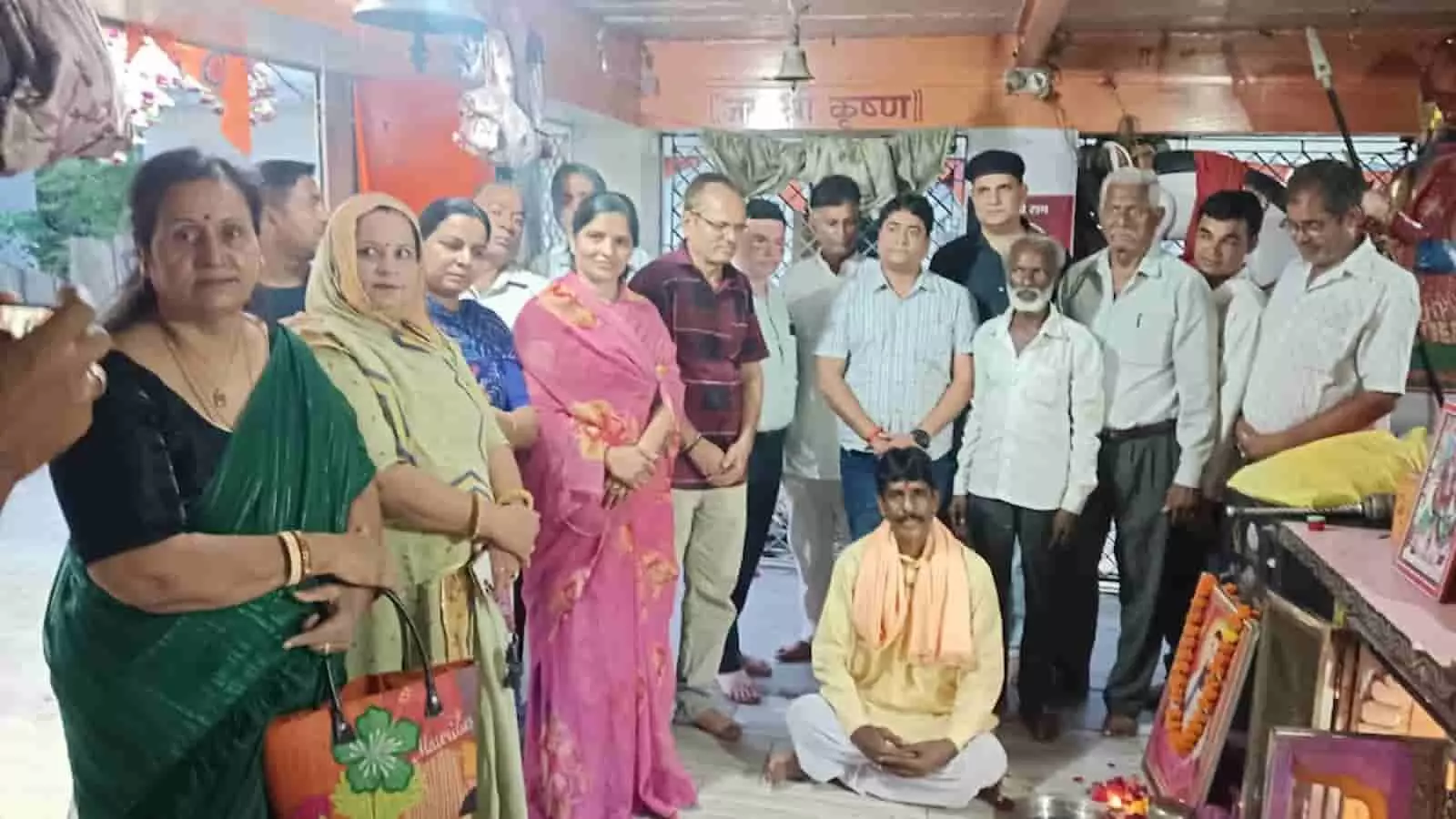 तस्वीर में मंदिर के भीतर एकत्र लोग पूजा स्थल के सामने खड़े और बैठे दिखाई दे रहे हैं। तस्वीर में मंदिर के भीतर एकत्र लोग पूजा स्थल के सामने खड़े और बैठे दिखाई दे रहे हैं।