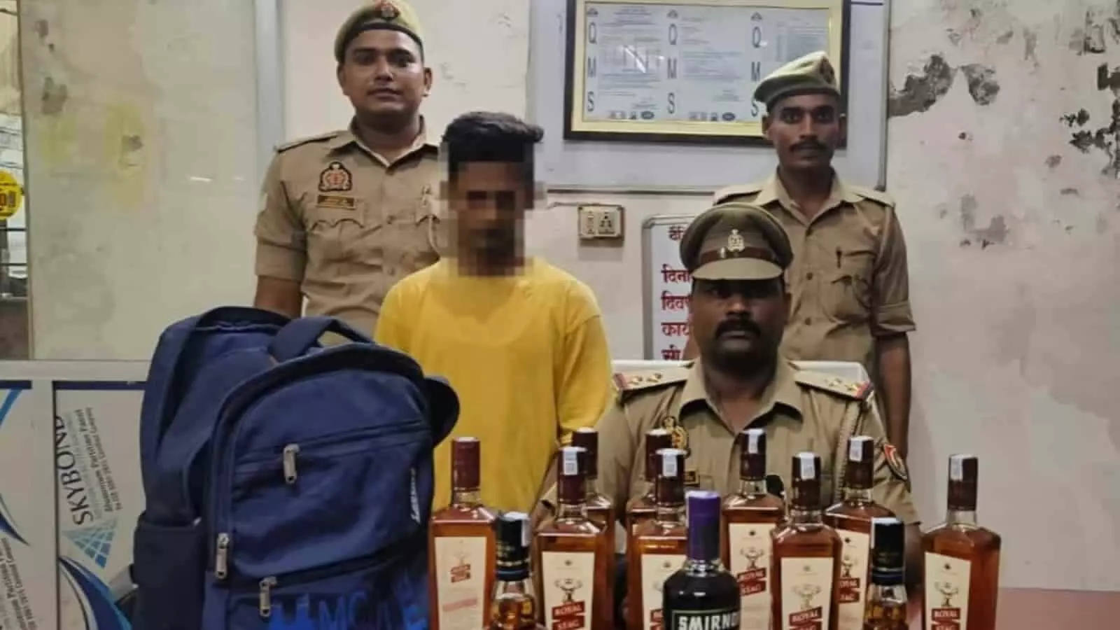 मुगलसराय पुलिस स्टेशन में जब्त अंग्रेजी शराब और नीले बैग के साथ खड़ा आरोपी युवक। मुगलसराय पुलिस स्टेशन में जब्त अंग्रेजी शराब और नीले बैग के साथ खड़ा आरोपी युवक।