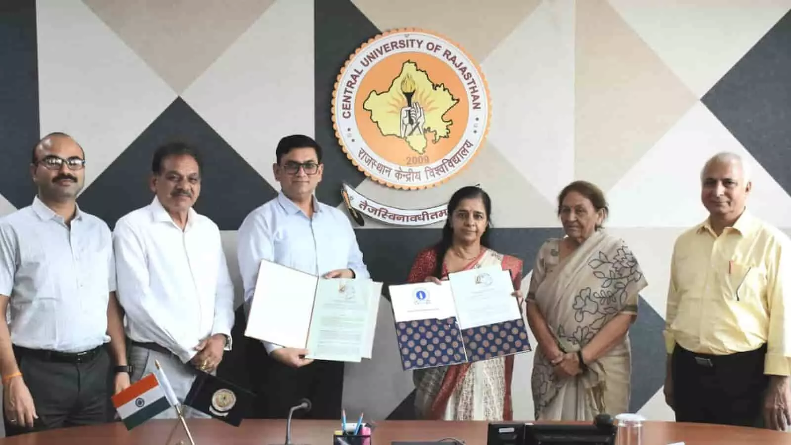 तस्वीर में राजस्थान केंद्रीय विश्वविद्यालय और जयपुर कॉलेज के अधिकारी एमओयू दस्तावेज दिखाते हुए खड़े हैं। तस्वीर में राजस्थान केंद्रीय विश्वविद्यालय और जयपुर कॉलेज के अधिकारी एमओयू दस्तावेज दिखाते हुए खड़े हैं।