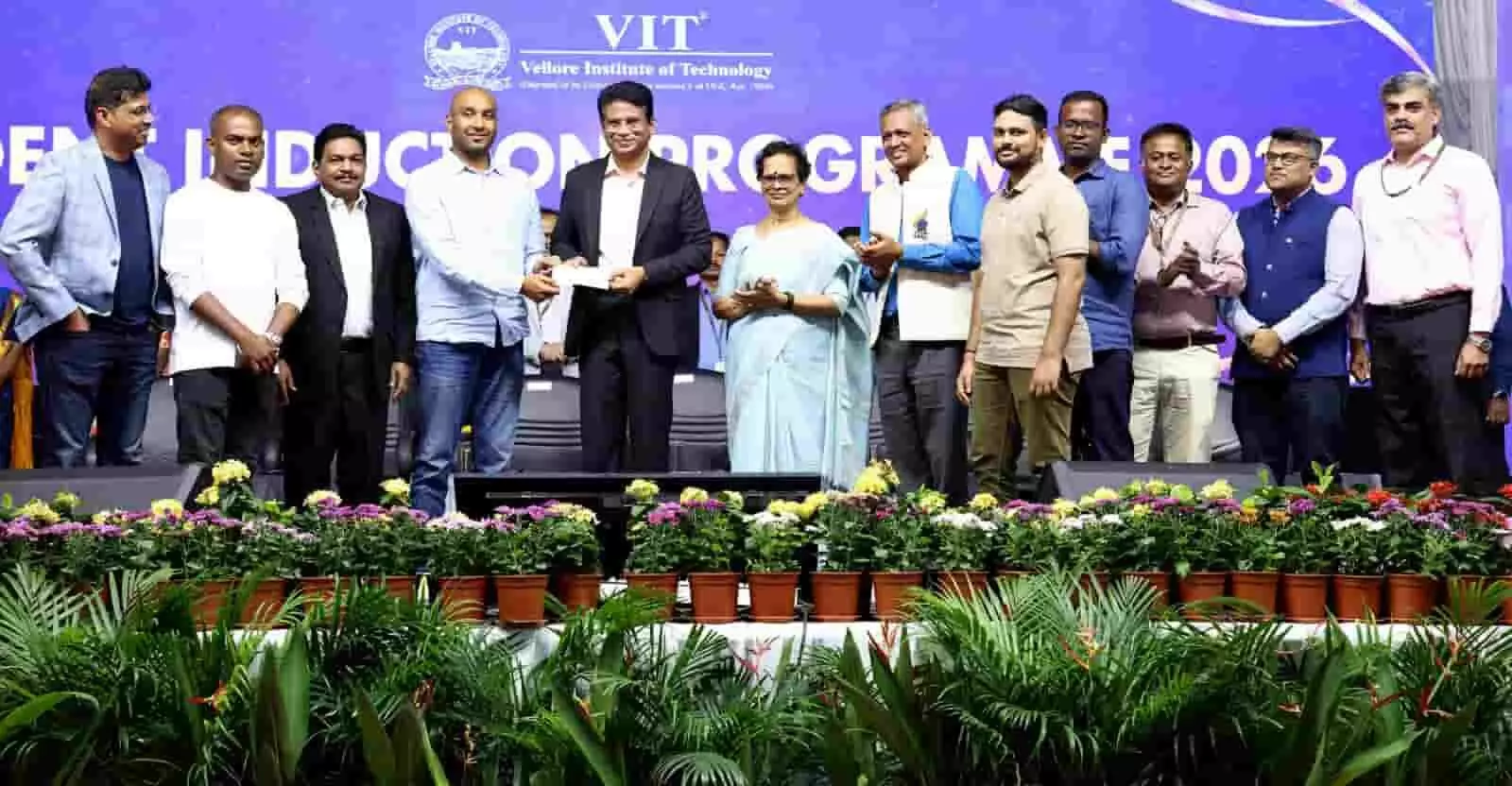 तस्वीर में VIT के मंच पर अधिकारियों द्वारा चेक सौंपने का दृश्य दिख रहा है। तस्वीर में VIT के मंच पर अधिकारियों द्वारा चेक सौंपने का दृश्य दिख रहा है।
