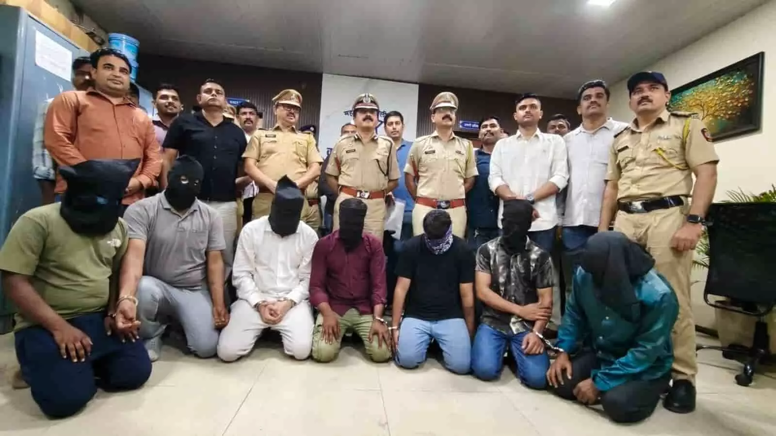 तस्वीर में पुलिस अधिकारी और हिरासत में लिए गए छह नकाबपोश आरोपी दिखाई दे रहे हैं। तस्वीर में पुलिस अधिकारी और हिरासत में लिए गए छह नकाबपोश आरोपी दिखाई दे रहे हैं।