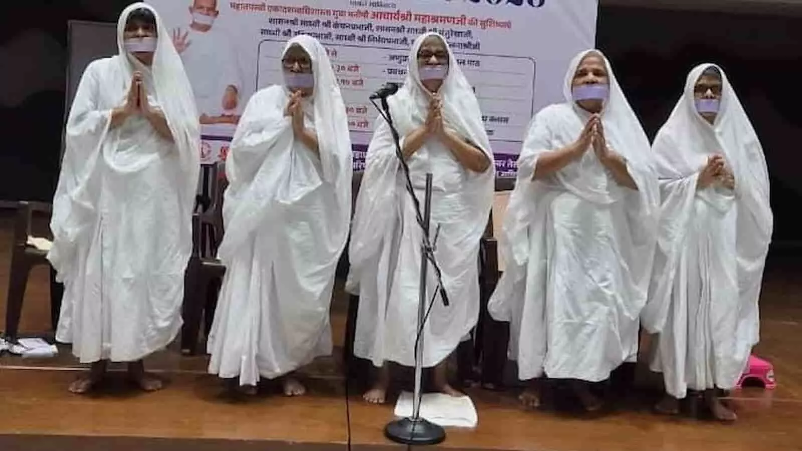 मंच पर हाथ जोड़े खड़ीं सफेद वस्त्रधारी जैन साध्वियों की तस्वीर। मंच पर हाथ जोड़े खड़ीं सफेद वस्त्रधारी जैन साध्वियों की तस्वीर।