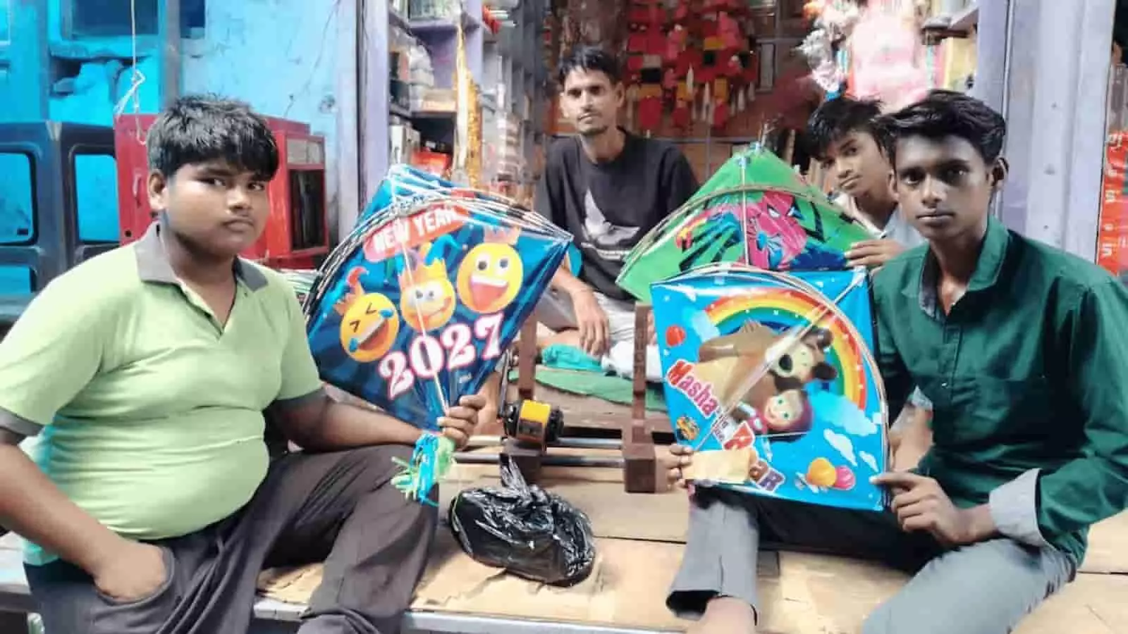 दुकान पर रंग-बिरंगी पतंगें लिए बच्चे और दुकानदार भरतपुर के भुसावर में नजर आ रहे हैं। दुकान पर रंग-बिरंगी पतंगें लिए बच्चे और दुकानदार भरतपुर के भुसावर में नजर आ रहे हैं।