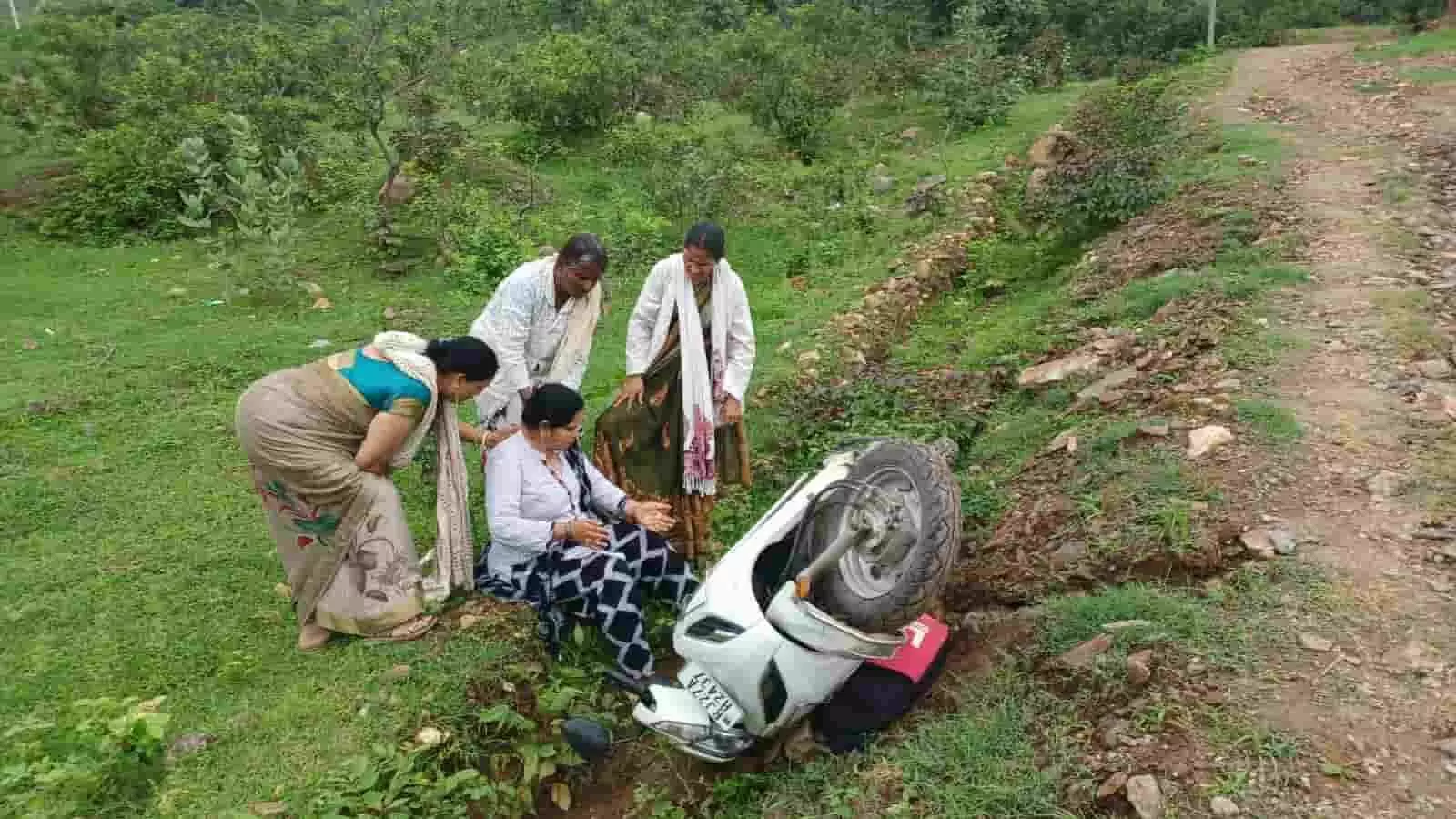 तस्वीर में कच्चे मार्ग के पास तीन महिलाएं दुर्घटनाग्रस्त स्कूटी के समीप बैठी घायल महिला की सहायता करती दिख रही हैं। तस्वीर में कच्चे मार्ग के पास तीन महिलाएं दुर्घटनाग्रस्त स्कूटी के समीप बैठी घायल महिला की सहायता करती दिख रही हैं।