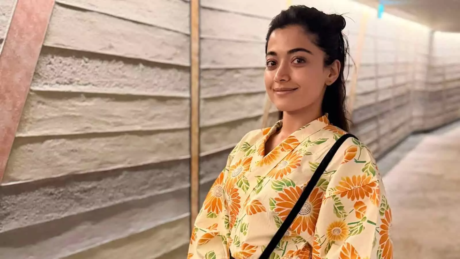 तस्वीर में अभिनेत्री रश्मिका मंदाना इंडोर कॉरिडोर के पास खड़े होकर मुस्कुराती दिख रही हैं। तस्वीर में अभिनेत्री रश्मिका मंदाना इंडोर कॉरिडोर के पास खड़े होकर मुस्कुराती दिख रही हैं।