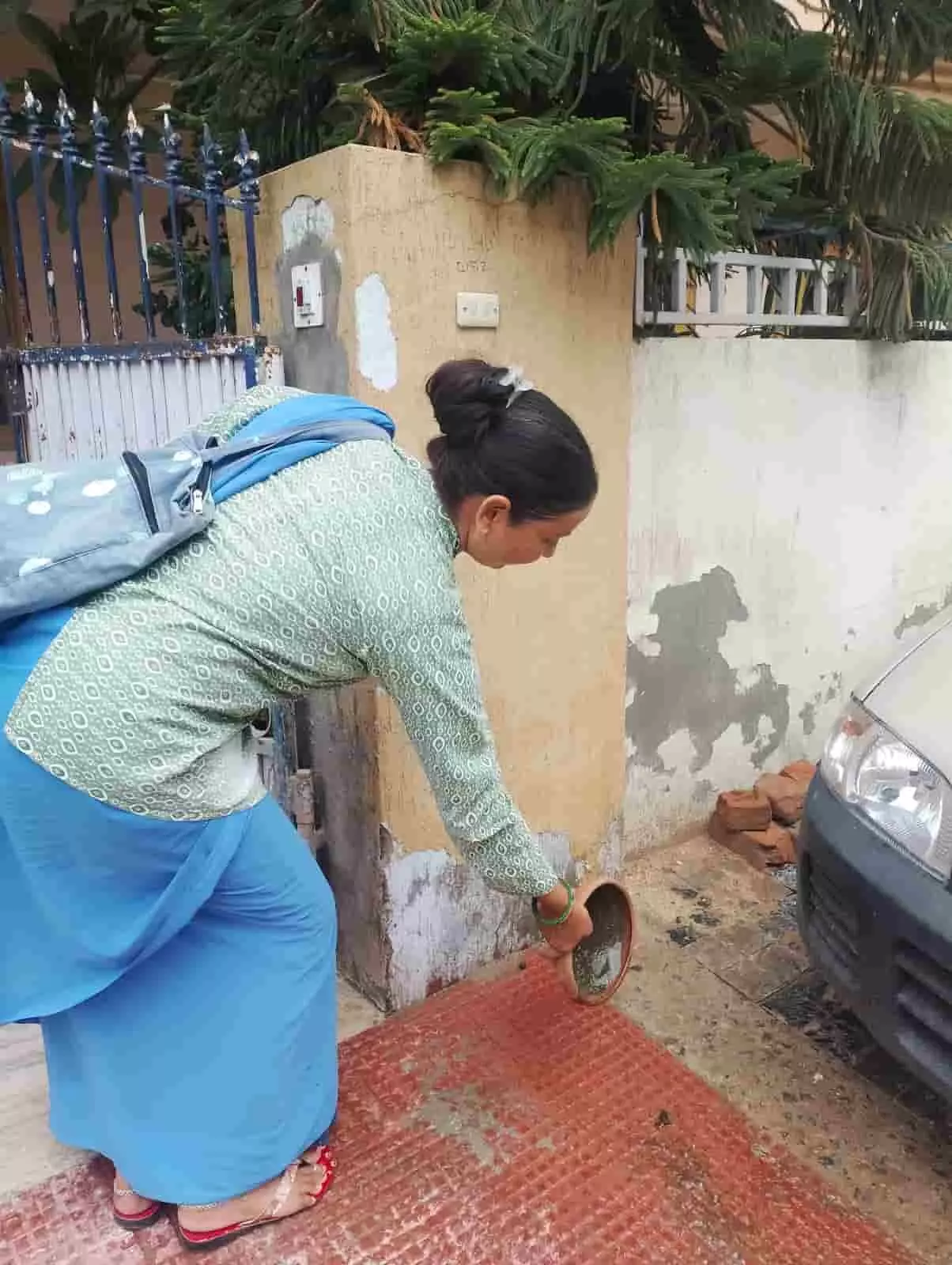 तस्वीर में महिला जयपुर में घर के बाहर पानी का बर्तन खाली करती हुई दिख रही है। तस्वीर में महिला जयपुर में घर के बाहर पानी का बर्तन खाली करती हुई दिख रही है।