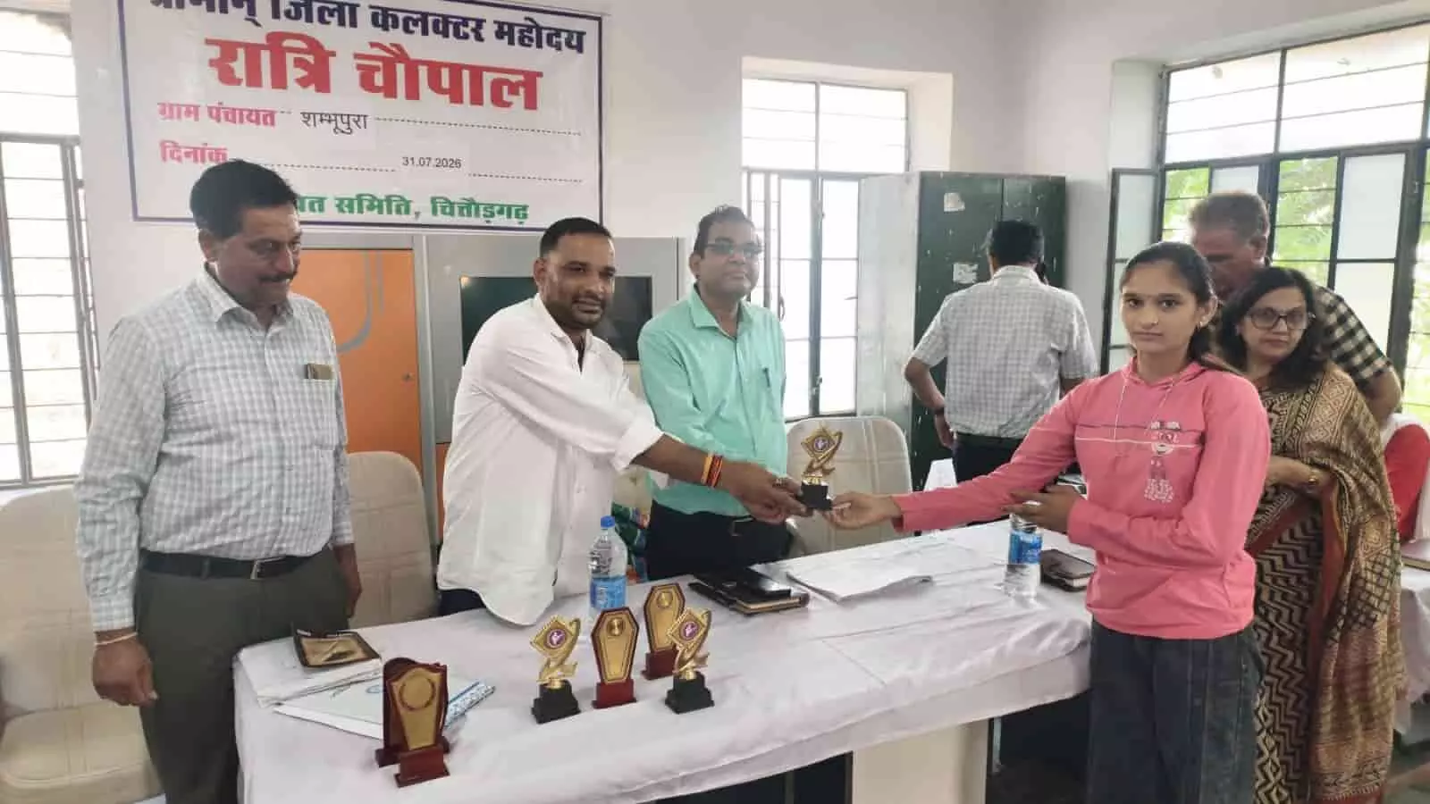 तस्वीर में शंभूपुरा ग्राम पंचायत कार्यालय में अधिकारियों द्वारा छात्रा को पुरस्कार देते हुए दिखाया गया है। तस्वीर में शंभूपुरा ग्राम पंचायत कार्यालय में अधिकारियों द्वारा छात्रा को पुरस्कार देते हुए दिखाया गया है।