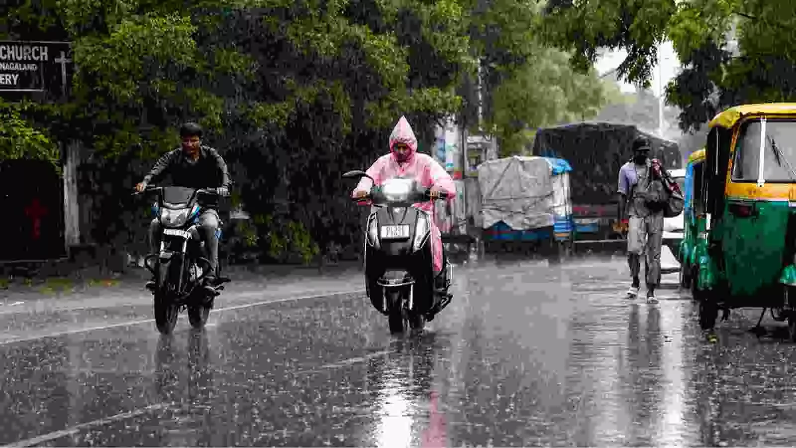बारिश में सड़क पर वाहन चलाते लोग दिखाई दे रहे हैं। बारिश में सड़क पर वाहन चलाते लोग दिखाई दे रहे हैं।