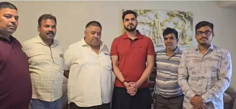 तस्वीर में छह पुरुष एक कमरे में खड़े होकर कैमरे की ओर देख रहे हैं। तस्वीर में छह पुरुष एक कमरे में खड़े होकर कैमरे की ओर देख रहे हैं।