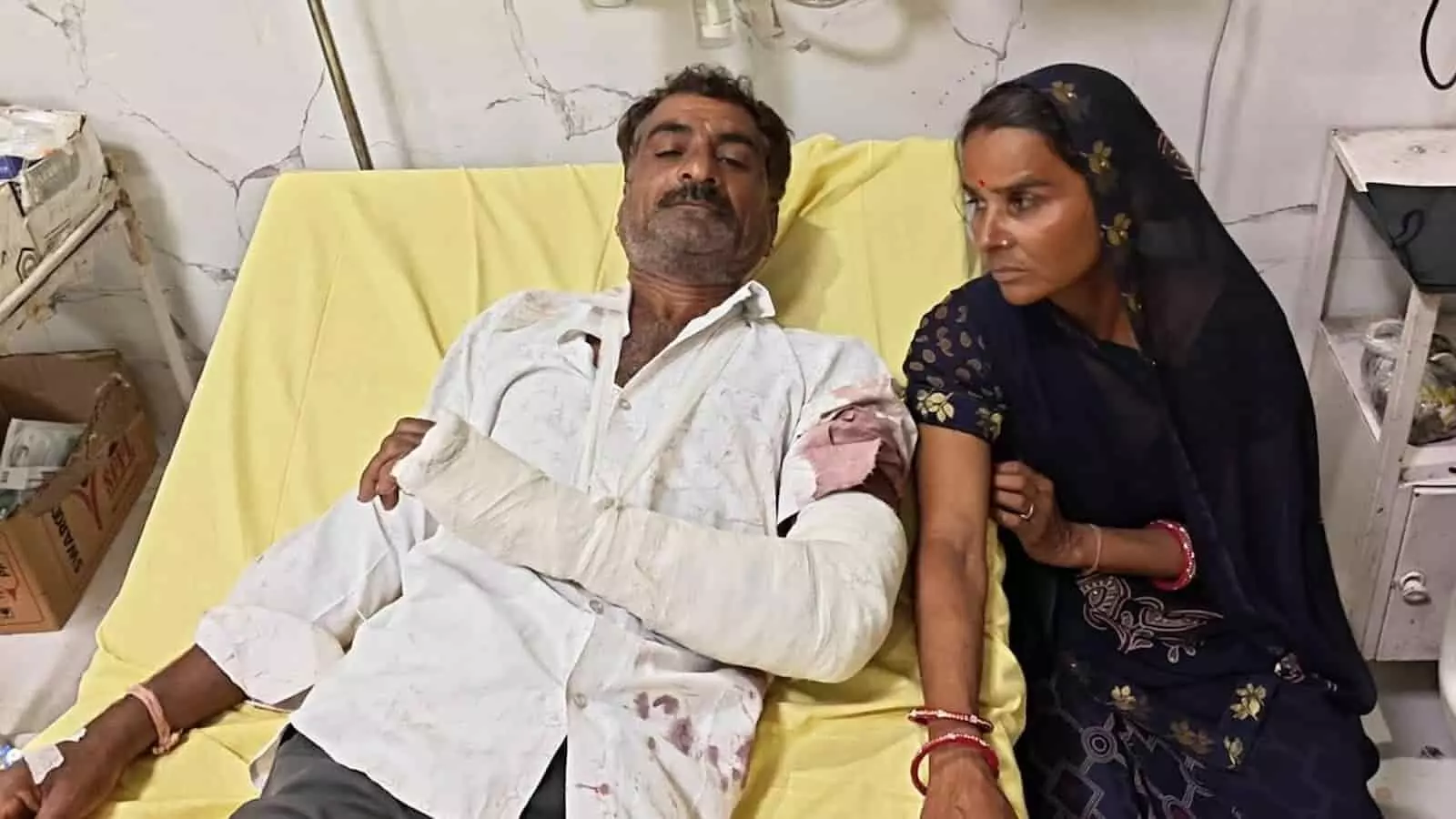 अस्पताल के बिस्तर पर लेटे घायल राजेश जोशी और पास बैठी उनकी पत्नी। अस्पताल के बिस्तर पर लेटे घायल राजेश जोशी और पास बैठी उनकी पत्नी।
