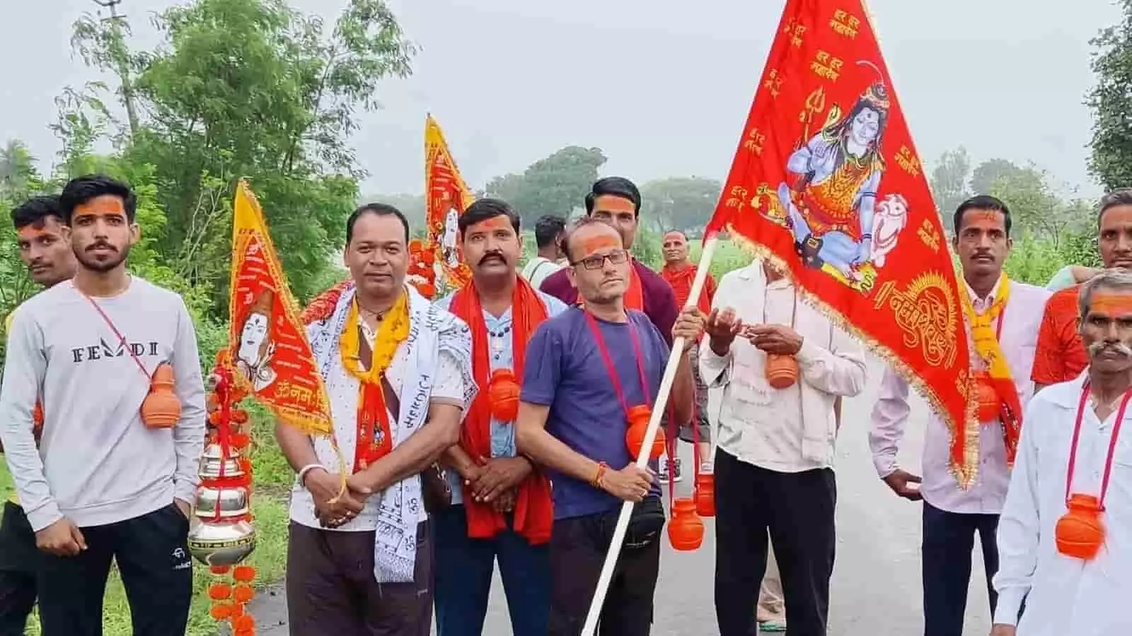 तस्वीर में महाकाल कावड़ यात्रा के दौरान हाथ में झंडा और कावड़ लिए श्रद्धालु सड़क पर खड़े हैं। तस्वीर में महाकाल कावड़ यात्रा के दौरान हाथ में झंडा और कावड़ लिए श्रद्धालु सड़क पर खड़े हैं।