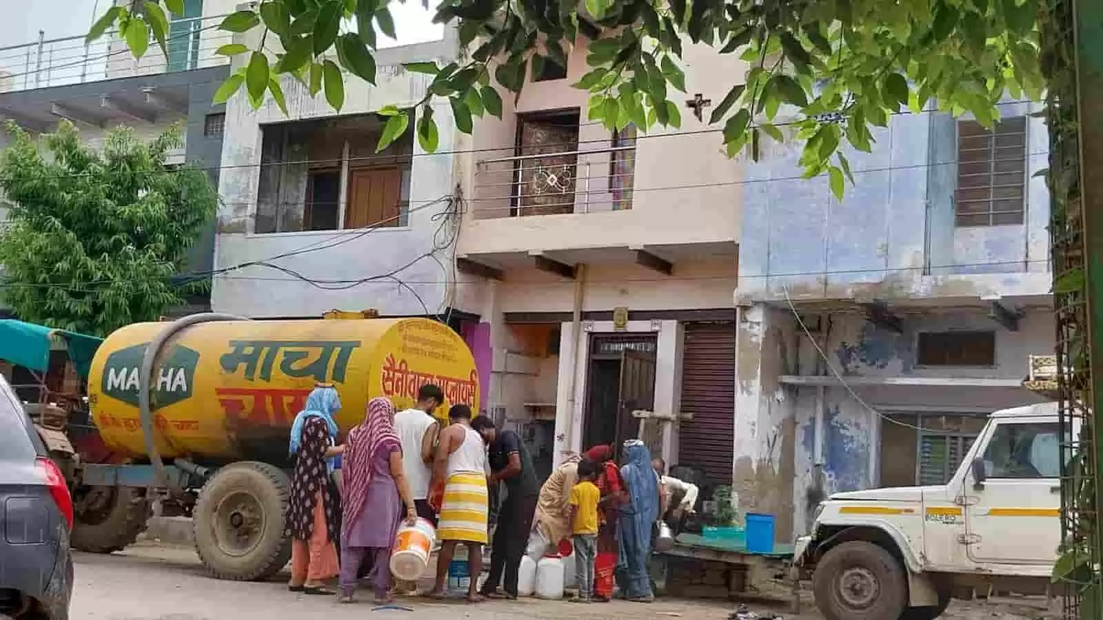 शहर के घनी आबादी वाले क्षेत्र की गली में टैंकर से पानी भरते लोग। शहर के घनी आबादी वाले क्षेत्र की गली में टैंकर से पानी भरते लोग।