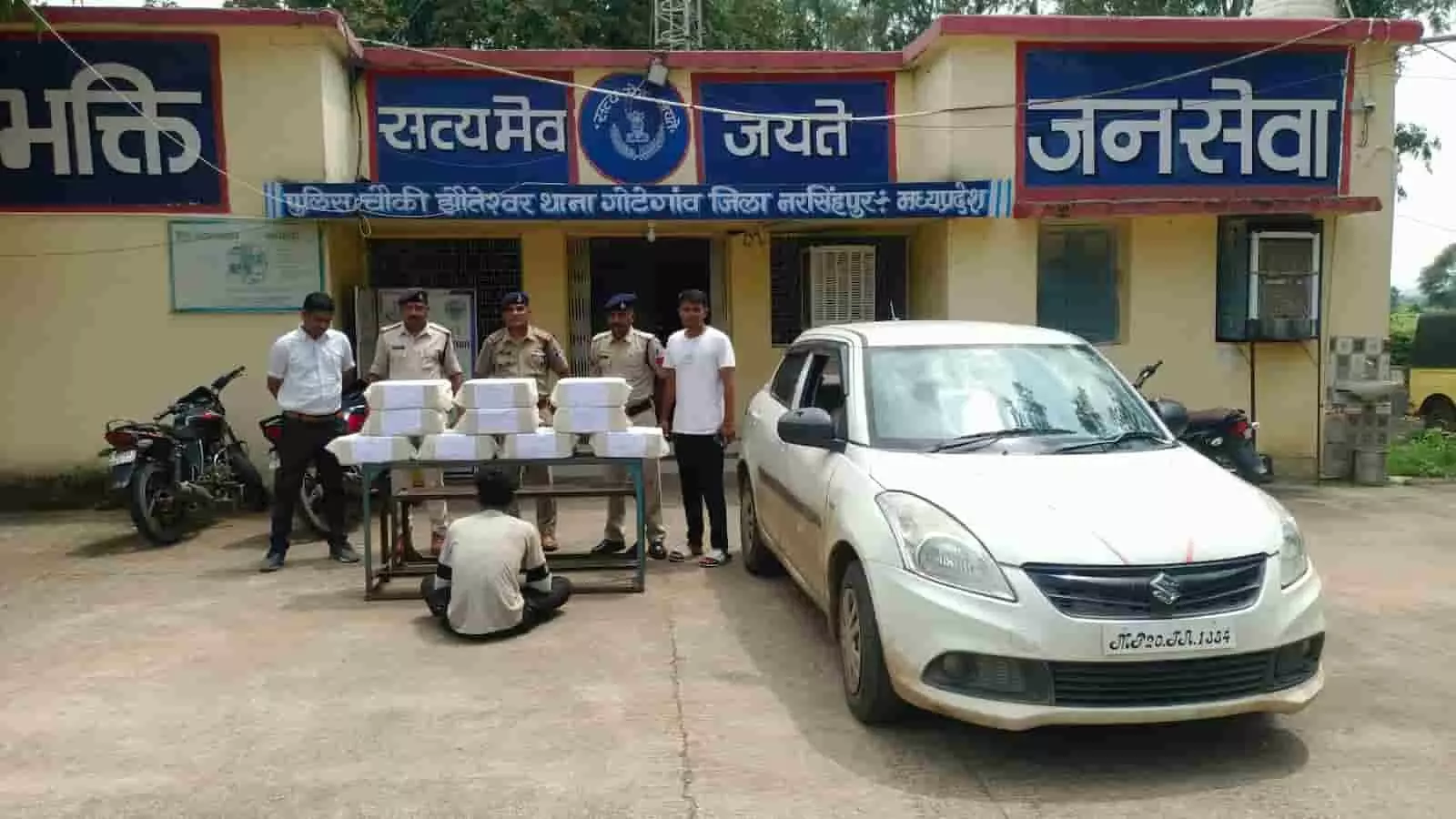 पुलिस चौकी के सामने अवैध शराब के बक्से और स्विफ्ट कार के साथ खड़े लोग। पुलिस चौकी के सामने अवैध शराब के बक्से और स्विफ्ट कार के साथ खड़े लोग।