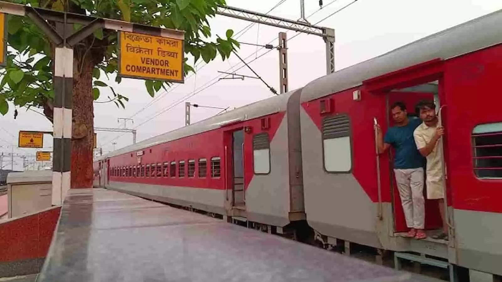 तस्वीर में दिख रही ट्रेन के दरवाजे पर दो यात्री खड़े हैं। तस्वीर में दिख रही ट्रेन के दरवाजे पर दो यात्री खड़े हैं।