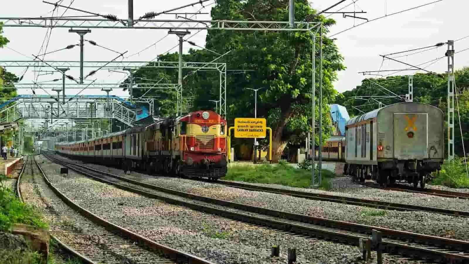 तस्वीर में रेलवे ट्रैक पर खड़ी एक ट्रेन और ओवरहेड बिजली के तार दिखाई दे रहे हैं। तस्वीर में रेलवे ट्रैक पर खड़ी एक ट्रेन और ओवरहेड बिजली के तार दिखाई दे रहे हैं।