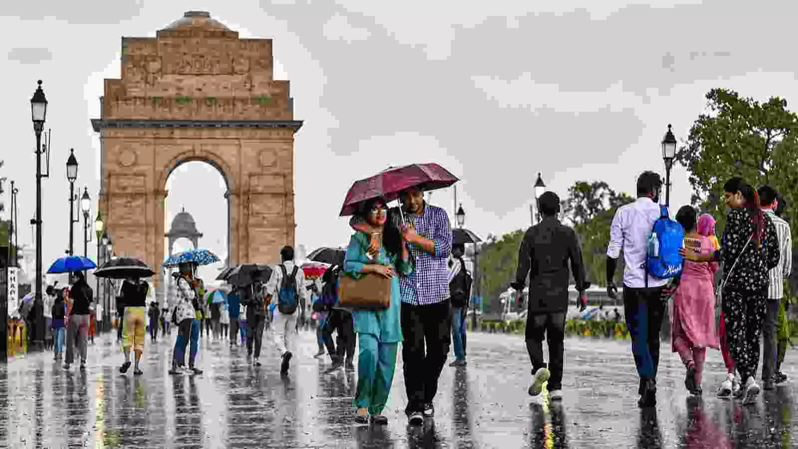 वर्षा के दौरान इंडिया गेट के पास लोग दिल्ली में मौसम बदलाव के बीच चल रहे हैं। वर्षा के दौरान इंडिया गेट के पास लोग दिल्ली में मौसम बदलाव के बीच चल रहे हैं।
