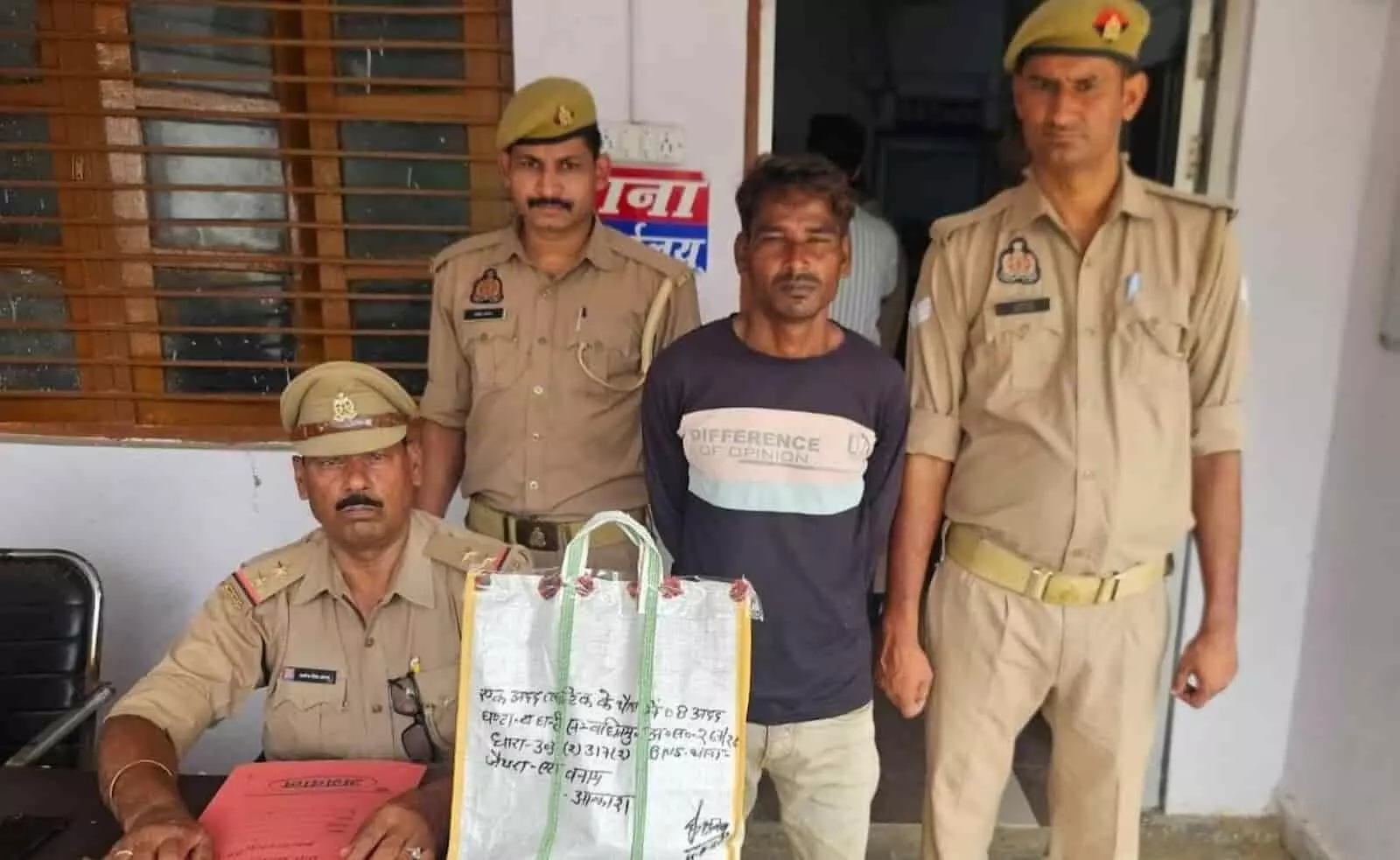 थाना जैथरा परिसर में पुलिसकर्मियों के साथ खड़े घंटा चोरी के गिरफ्तार आरोपी की तस्वीर। थाना जैथरा परिसर में पुलिसकर्मियों के साथ खड़े घंटा चोरी के गिरफ्तार आरोपी की तस्वीर।