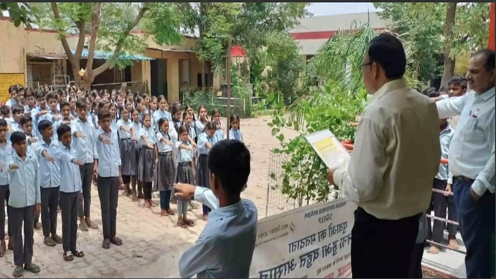 विद्यालय परिसर में शिक्षक के नेतृत्व में शपथ लेते विद्यार्थी और शिक्षक नजर आ रहे हैं। विद्यालय परिसर में शिक्षक के नेतृत्व में शपथ लेते विद्यार्थी और शिक्षक नजर आ रहे हैं।