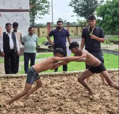 मिट्टी के अखाड़े में कुश्ती करते हुए पहलवान और पीछे खड़े लोग स्पोर्ट्स स्टेडियम में। मिट्टी के अखाड़े में कुश्ती करते हुए पहलवान और पीछे खड़े लोग स्पोर्ट्स स्टेडियम में।