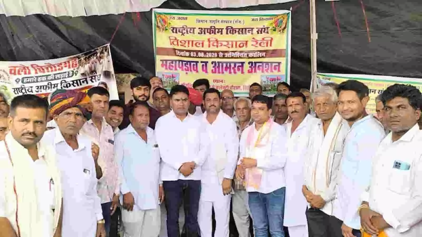 चित्तौड़गढ़ में धरने के दौरान बैनर के सामने खड़े राष्ट्रीय अफीम किसान संघ के सदस्य और किसान। चित्तौड़गढ़ में धरने के दौरान बैनर के सामने खड़े राष्ट्रीय अफीम किसान संघ के सदस्य और किसान।