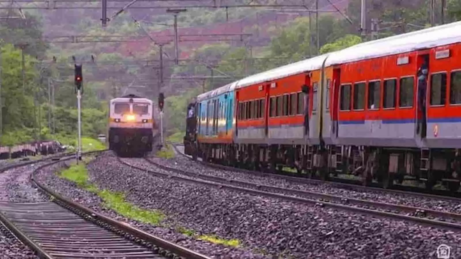 तस्वीर में रेलवे पटरियों पर ट्रेन और सामने से आता इंजन दिखाई दे रहा है। तस्वीर में रेलवे पटरियों पर ट्रेन और सामने से आता इंजन दिखाई दे रहा है।