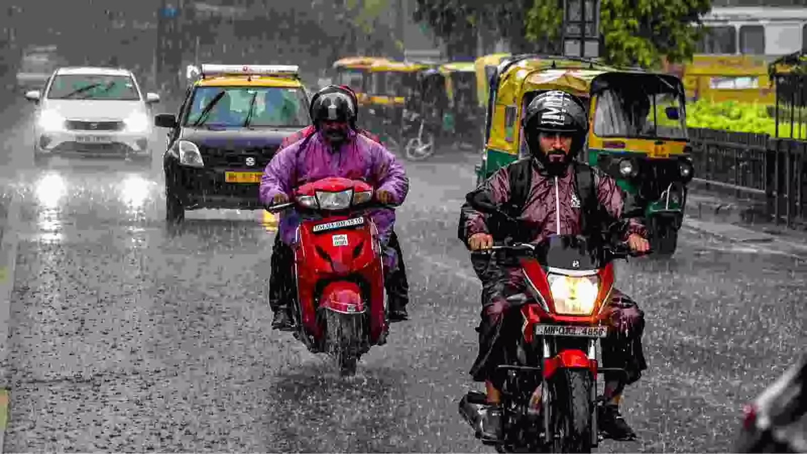 बरसात के दौरान सड़क पर वाहन चलाते लोग| बरसात के दौरान सड़क पर वाहन चलाते लोग|