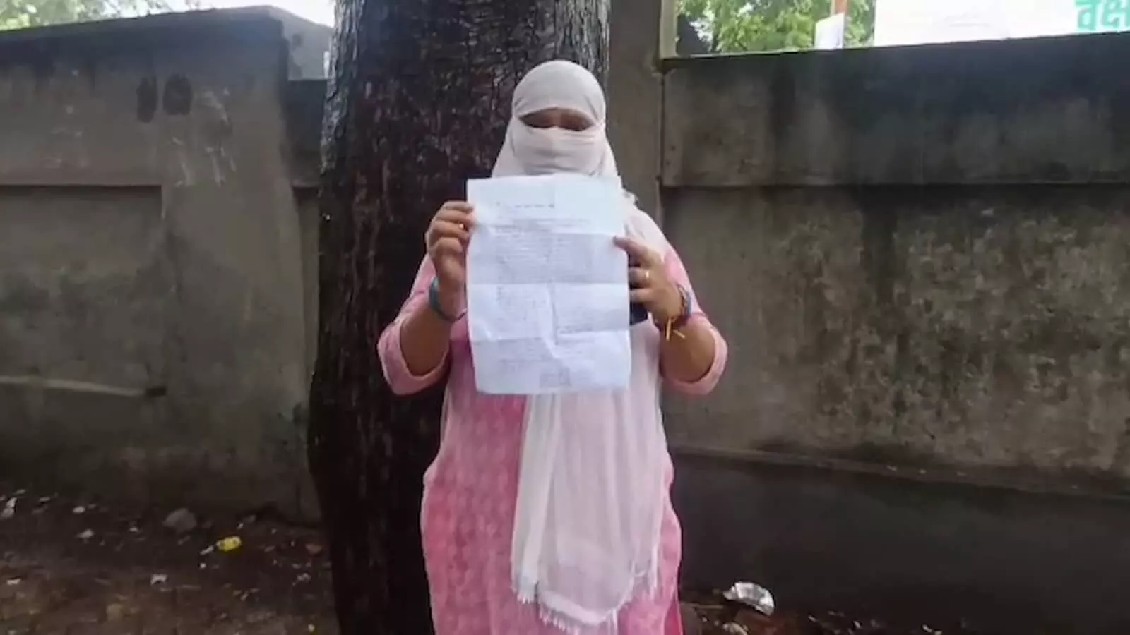 तस्वीर में गुलाबी सूट पहने महिला हाथ में प्रार्थना पत्र पकड़े नजर आ रही है। तस्वीर में गुलाबी सूट पहने महिला हाथ में प्रार्थना पत्र पकड़े नजर आ रही है।