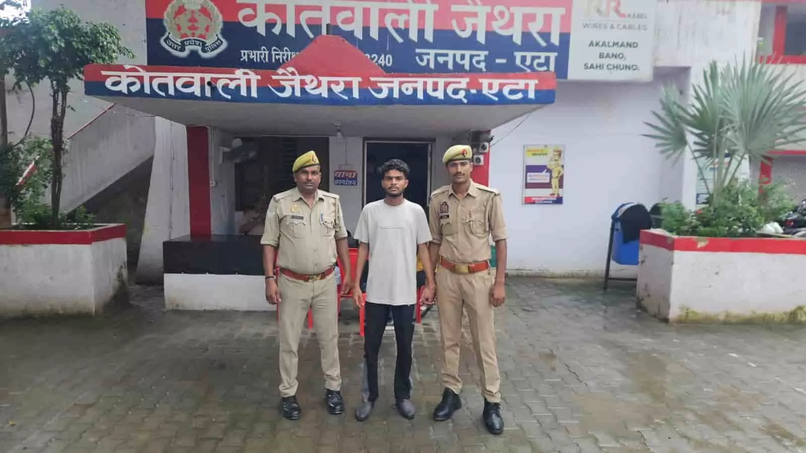 तस्वीर में एटा के जैथरा थाने के बाहर दो पुलिसकर्मी एक अभियुक्त को पकड़े खड़े हैं। तस्वीर में एटा के जैथरा थाने के बाहर दो पुलिसकर्मी एक अभियुक्त को पकड़े खड़े हैं।