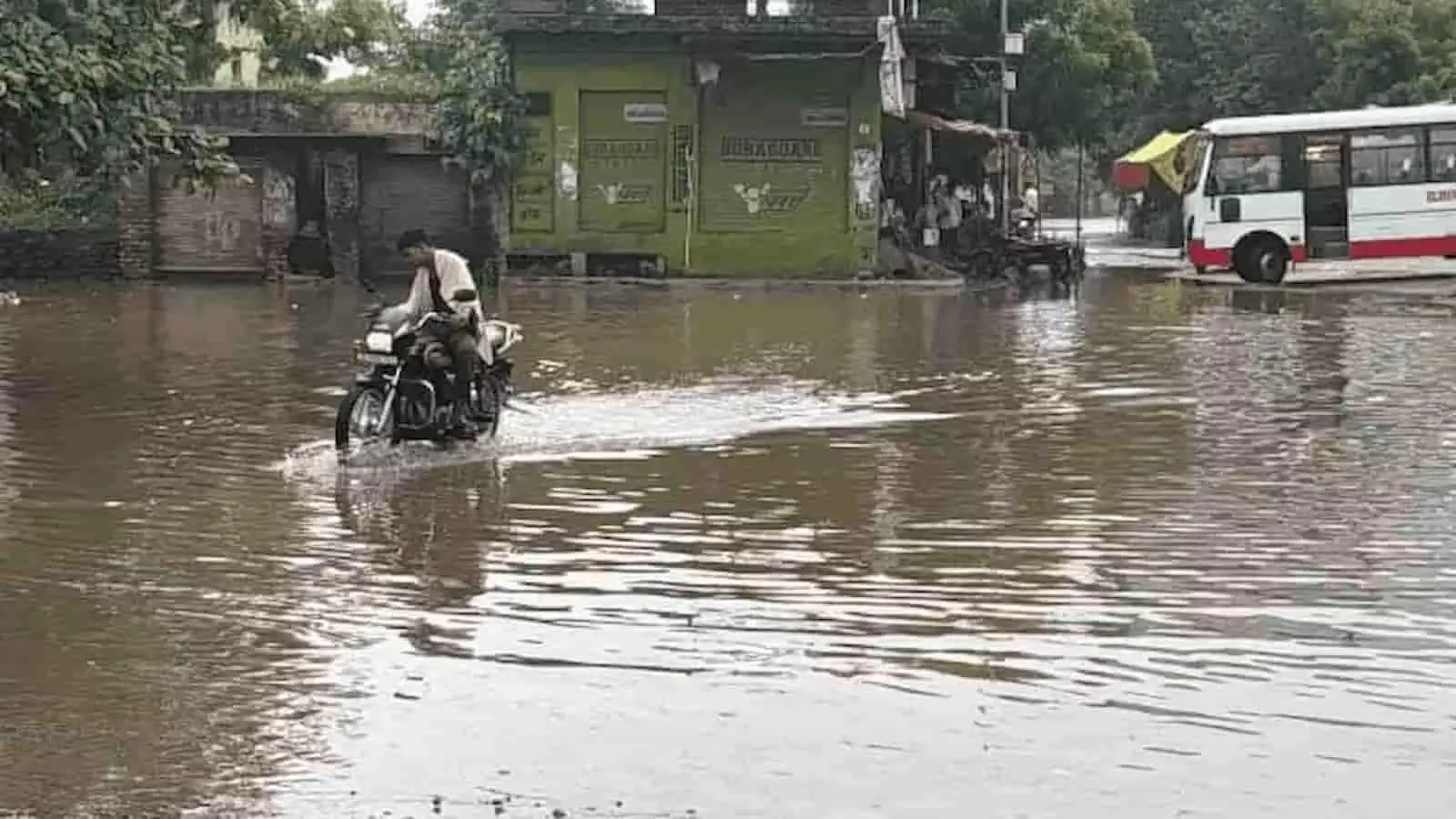 तस्वीर में डीग की जलभराव वाली सड़क पर मोटरसाइकिल चलाता हुआ एक व्यक्ति दिखाई दे रहा है। तस्वीर में डीग की जलभराव वाली सड़क पर मोटरसाइकिल चलाता हुआ एक व्यक्ति दिखाई दे रहा है।