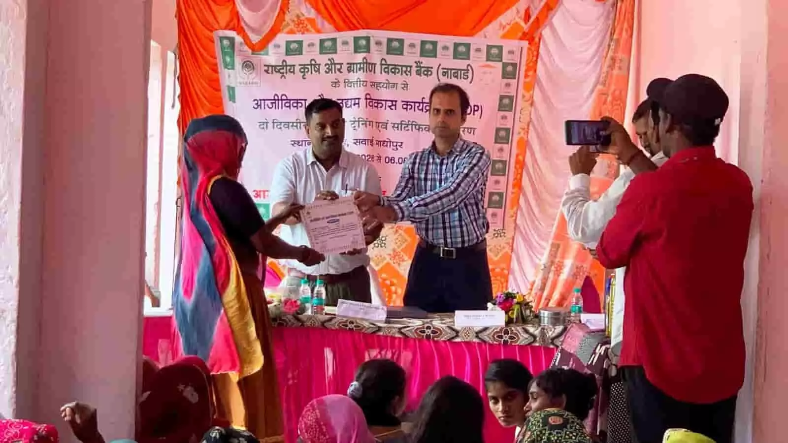 तस्वीर में सवाई माधोपुर में आयोजित कार्यक्रम के दौरान अधिकारी महिला प्रतिभागी को प्रमाण-पत्र देते दिख रहे हैं। तस्वीर में सवाई माधोपुर में आयोजित कार्यक्रम के दौरान अधिकारी महिला प्रतिभागी को प्रमाण-पत्र देते दिख रहे हैं।
