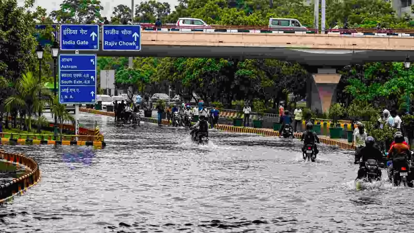 सड़क पर जलभराव के बीच वाहन चलाते लोग| सड़क पर जलभराव के बीच वाहन चलाते लोग|
