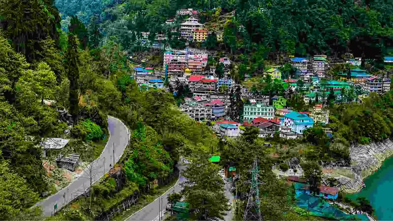 पहाड़ियों के बीच स्थित बस्तियों और सड़क का दृश्य सिक्किम में भारत के 22वें राज्य के रूप में विलय के संदर्भ में। पहाड़ियों के बीच स्थित बस्तियों और सड़क का दृश्य सिक्किम में भारत के 22वें राज्य के रूप में विलय के संदर्भ में।