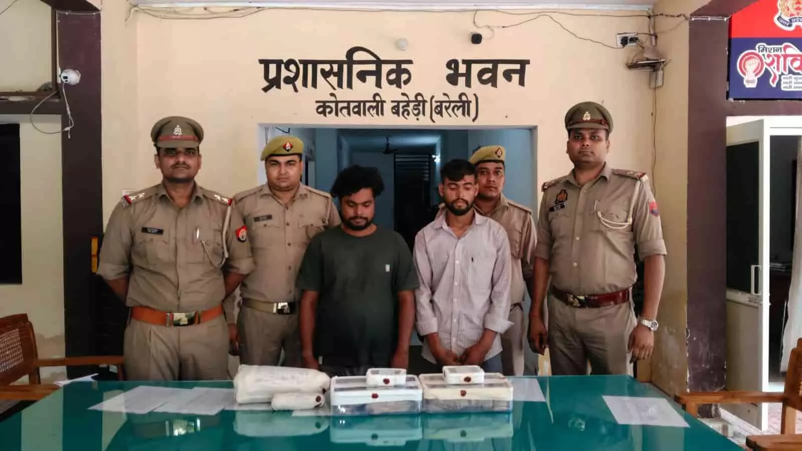 तस्वीर में बहेड़ी कोतवाली में खड़े पुलिसकर्मी और दो गिरफ्तार आरोपी दिख रहे हैं। तस्वीर में बहेड़ी कोतवाली में खड़े पुलिसकर्मी और दो गिरफ्तार आरोपी दिख रहे हैं।