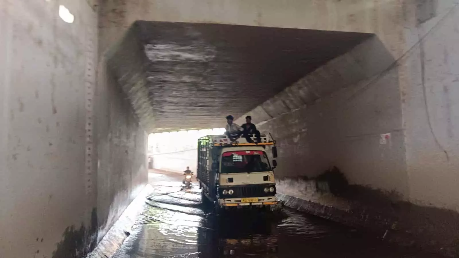 गुलाबनगर की रेलवे पुलिया के नीचे पानी भरे मार्ग से गुजरता वाहन और लोग। गुलाबनगर की रेलवे पुलिया के नीचे पानी भरे मार्ग से गुजरता वाहन और लोग।