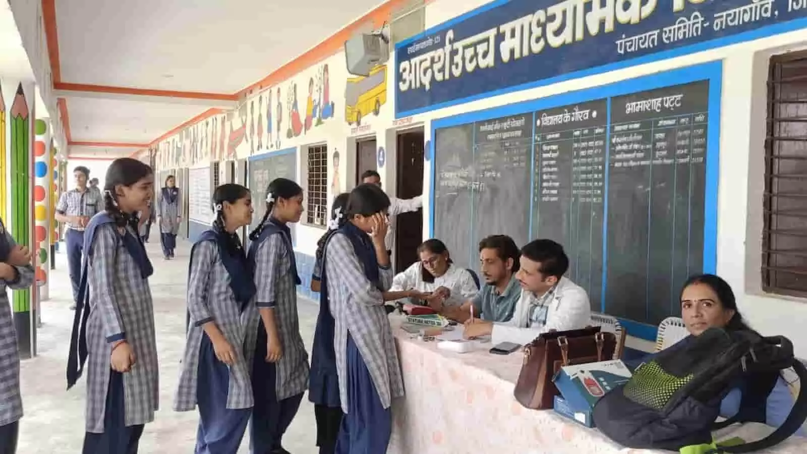 आदर्श उच्च माध्यमिक विद्यालय थाणा के गलियारे में स्वास्थ्य परीक्षण करते चिकित्साकर्मी और खड़े हुए विद्यार्थी। आदर्श उच्च माध्यमिक विद्यालय थाणा के गलियारे में स्वास्थ्य परीक्षण करते चिकित्साकर्मी और खड़े हुए विद्यार्थी।