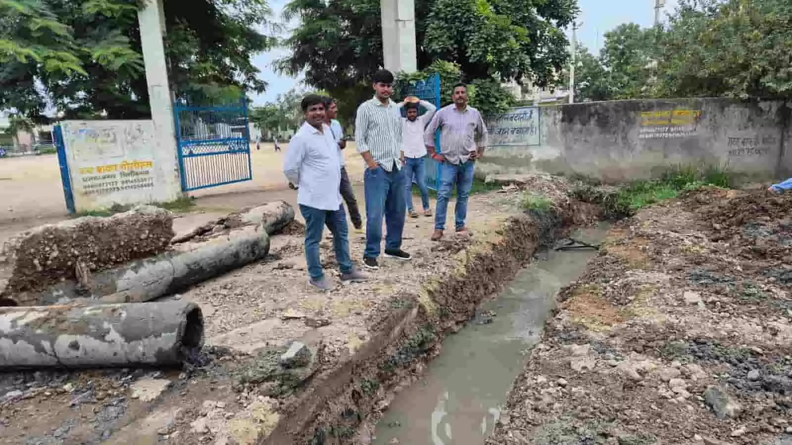 तस्वीर में बस्सी स्कूल के बाहर नई नाली का निर्माण कार्य और खड़े लोग दिख रहे हैं। तस्वीर में बस्सी स्कूल के बाहर नई नाली का निर्माण कार्य और खड़े लोग दिख रहे हैं।