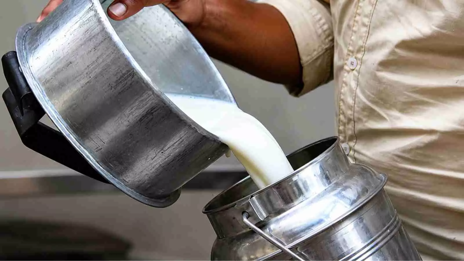 बर्तन में दूध डालते हुए एक व्यक्ति महाराष्ट्र में दूध की कीमत बढ़ने के संदर्भ में। बर्तन में दूध डालते हुए एक व्यक्ति महाराष्ट्र में दूध की कीमत बढ़ने के संदर्भ में।