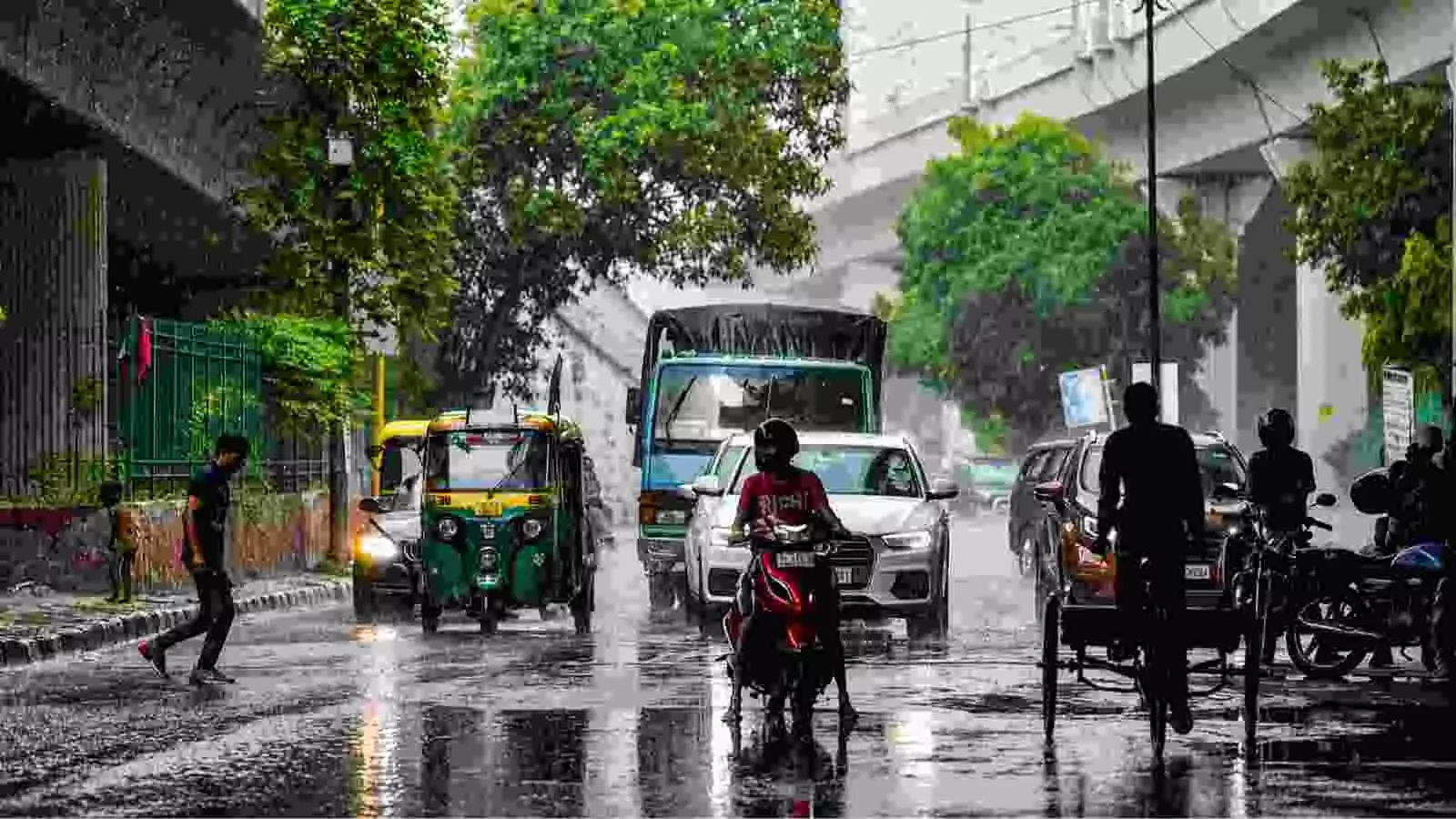बारिश के दौरान दिल्ली की सड़क पर वाहन चलाते लोग और राहगीर| बारिश के दौरान दिल्ली की सड़क पर वाहन चलाते लोग और राहगीर|