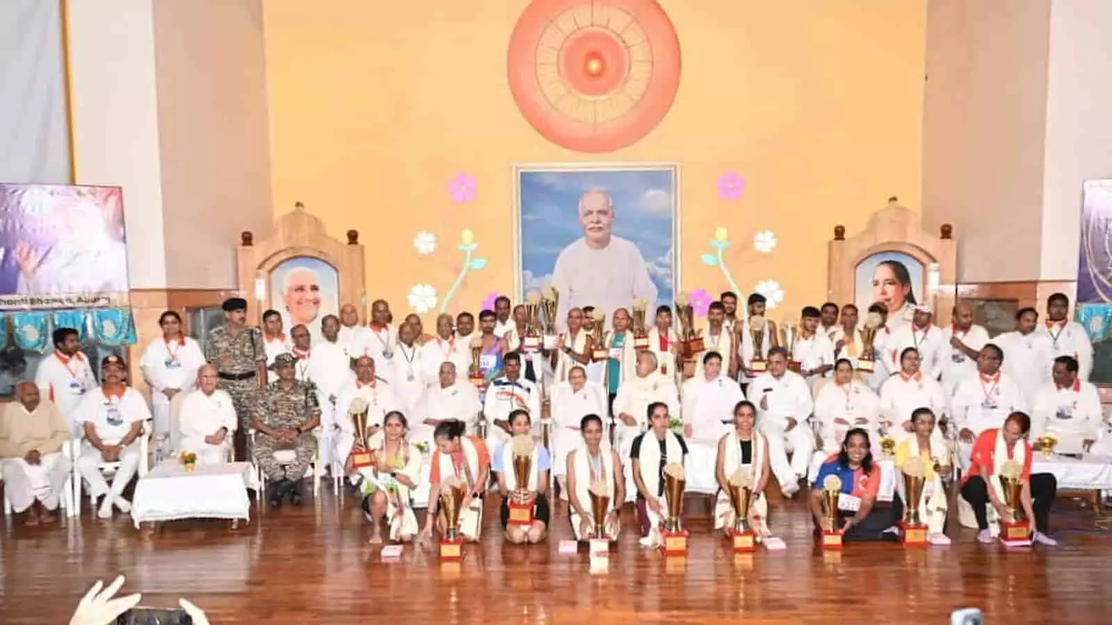 ब्रह्माकुमारीज के हॉल में मैराथन विजेताओं और अतिथियों को ट्रॉफी के साथ मंच पर देखा जा सकता है। ब्रह्माकुमारीज के हॉल में मैराथन विजेताओं और अतिथियों को ट्रॉफी के साथ मंच पर देखा जा सकता है।