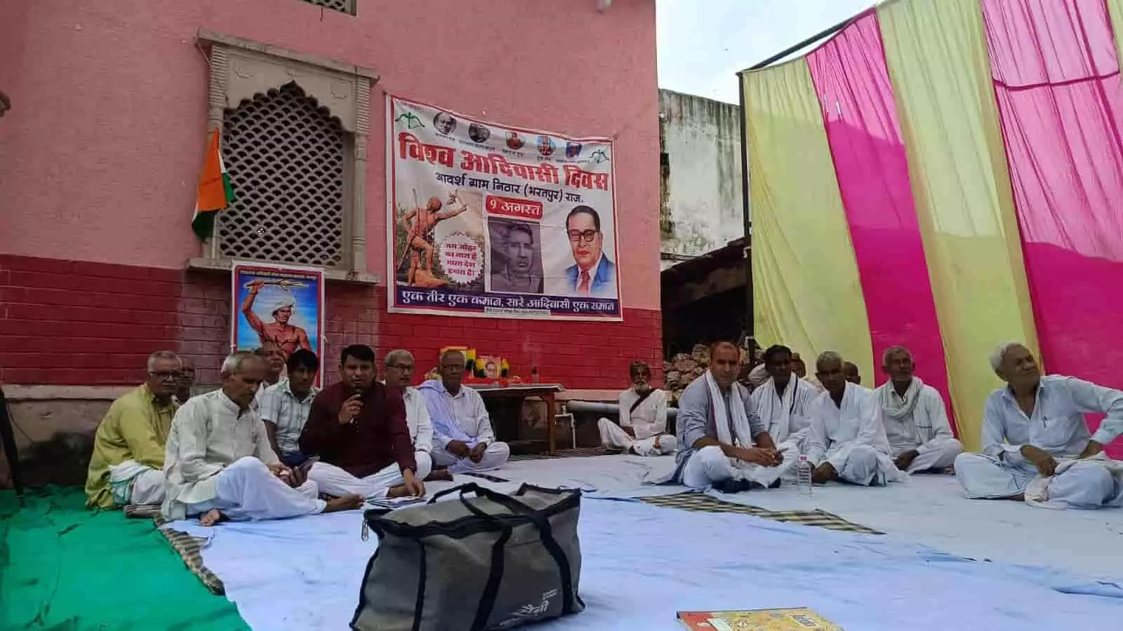 निठार के बाजार चौक में विश्व आदिवासी दिवस पर बैठे ग्रामीण। निठार के बाजार चौक में विश्व आदिवासी दिवस पर बैठे ग्रामीण।