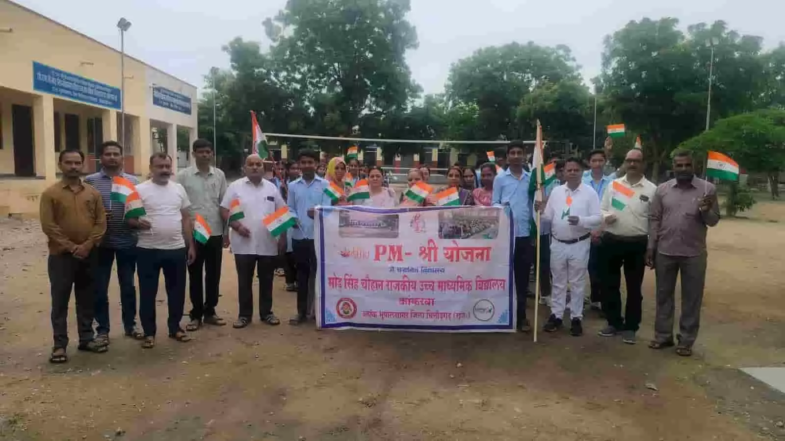 विद्यालय परिसर में हाथों में तिरंगा झंडे और बैनर थामे खड़े शिक्षक और विद्यार्थी। विद्यालय परिसर में हाथों में तिरंगा झंडे और बैनर थामे खड़े शिक्षक और विद्यार्थी।