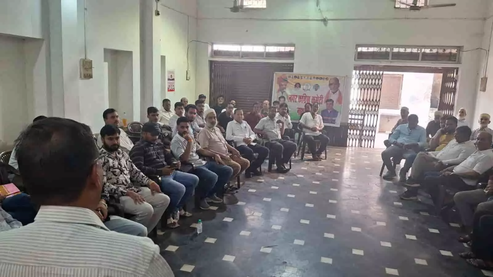तस्वीर में एक हॉल के भीतर बैठक में बैठे हुए कांग्रेस पार्टी के कार्यकर्ता और पदाधिकारी। तस्वीर में एक हॉल के भीतर बैठक में बैठे हुए कांग्रेस पार्टी के कार्यकर्ता और पदाधिकारी।