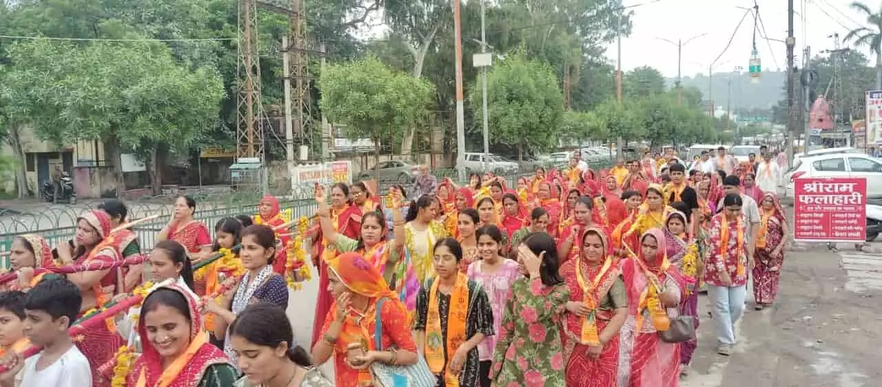 सड़क पर कांवड़ यात्रा निकालते हुए श्रद्धालु महिलाएं और पुरुष। सड़क पर कांवड़ यात्रा निकालते हुए श्रद्धालु महिलाएं और पुरुष।